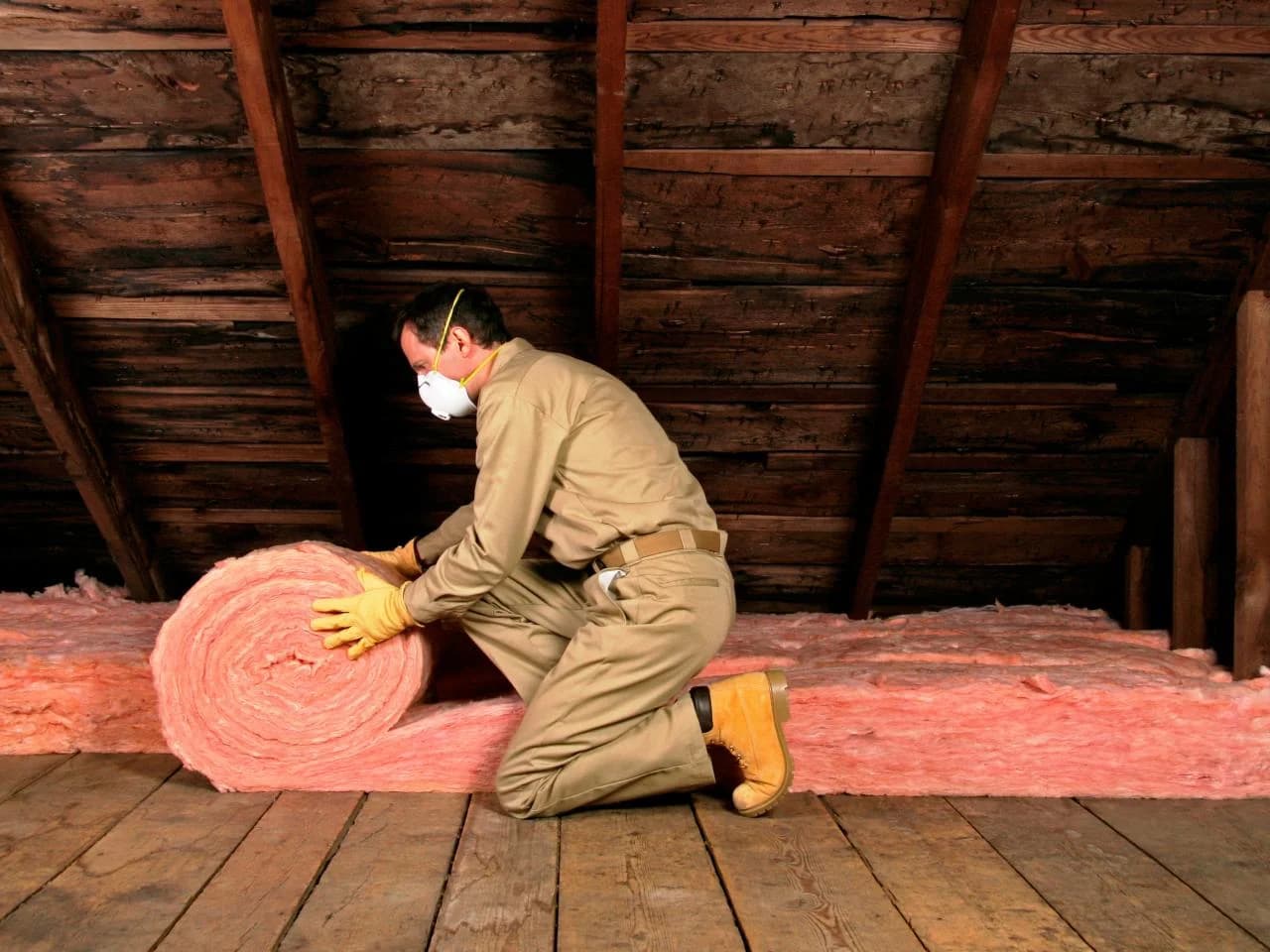 Artisan couvreur déroulant l'isolant dans les combles d'une maison à Toulouse pour Couvreur Toulouse